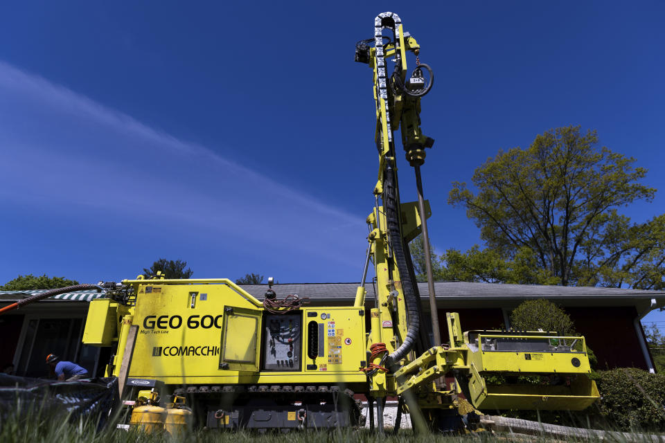 A drill rig sits outside a home during installation of a geothermal heat pump system in White Plains, N.Y., Monday, May 8, 2023. A water-filled loop runs several hundred feet deep in the yard and either carries heat away from, or into the house, depending on the season. Industry experts see the technology becoming increasingly popular in the coming years. (AP Photo/Julia Nikhinson)