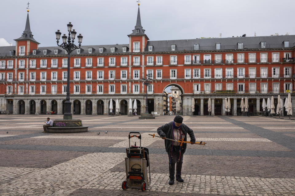 Spanish cartoonist Maria del Rosario "Chary" closes his stall after been told by local police to leave Mayor square in downtown Madrid, Spain, Sunday, March 15, 2020. Spain awoke to its first day of a nationwide quarantine on Sunday after the government declared a two-week state of emergency. The government imposed the special measures including the confinement of people to their homes unless shopping for food and medicine, going to and from work, and to meet other basic needs. The vast majority of people recover from the new coronavirus. According to the World Health Organization, most people recover in about two to six weeks, depending on the severity of the illness. (AP Photo/Bernat Armangue)