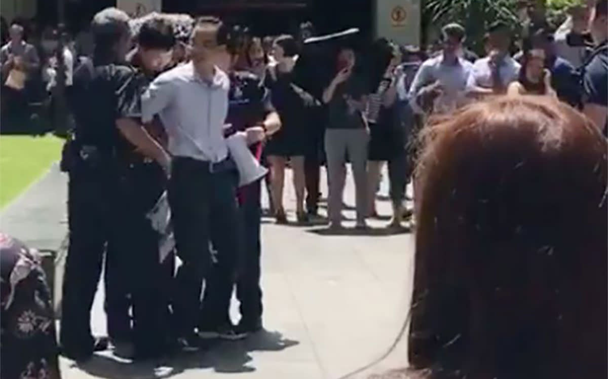 A video screen shot of Yan Jun being arrested after staging a one-man protest outside Raffles Place MRT on 3 July 2017.