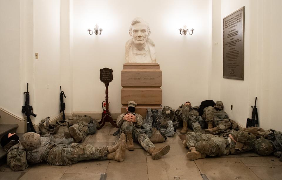 Members of the National Guard take a rest in the Rotunda of the Capitol, near a bust of Abraham Lincoln