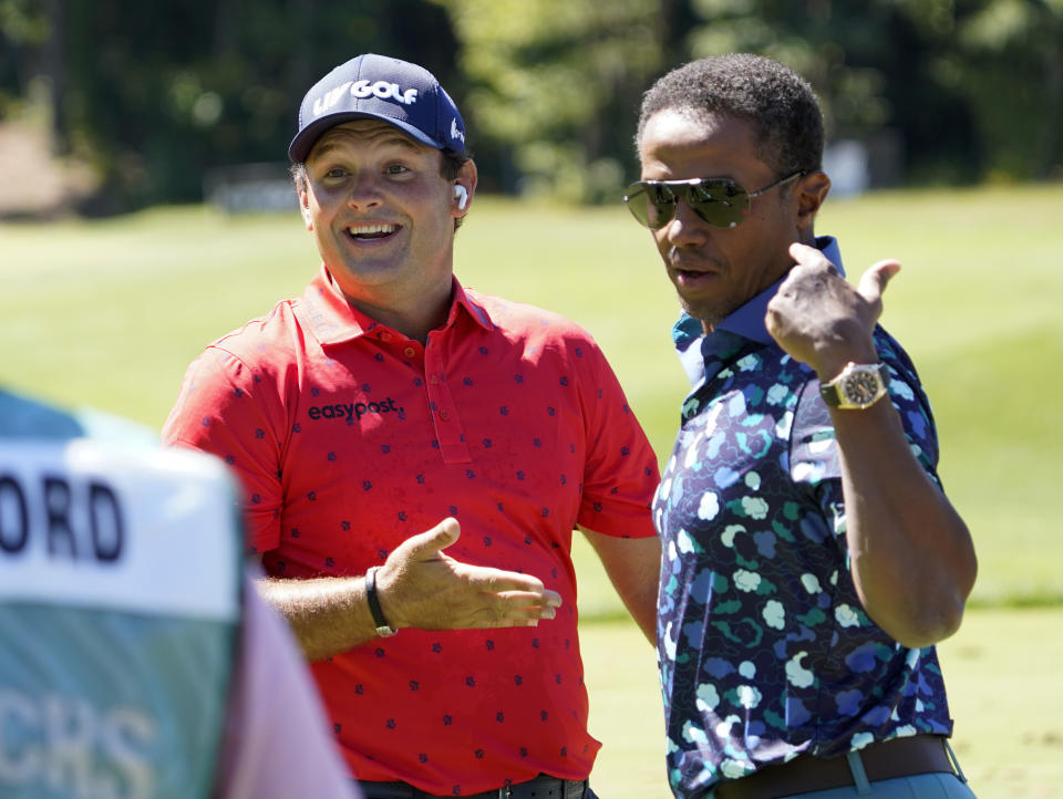 Patrick Reed, left, talks with LIV Golf Managing Director Majed Al Sorour before the start of the first round of the LIV Golf tournament, Friday, Sept. 2, 2022, in Bolton, Mass. (AP Photo/Mary Schwalm)