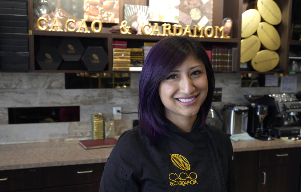 In this Monday, Sept. 16, 2019, photo Annie Rupani, owner of Cacao & Cardamom, poses for a photo inside one her shops in Houston. She's seen the amount that people spend on each visit drop in the past year. Like many retailers, she's going to put more effort and investment into her online business. (AP Photo/David J. Phillip)