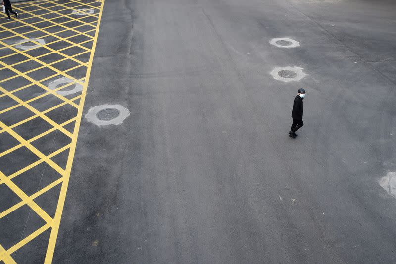 Man wearing a face mask crosses a road in Wuhan, the epicentre of the novel coronavirus outbreak