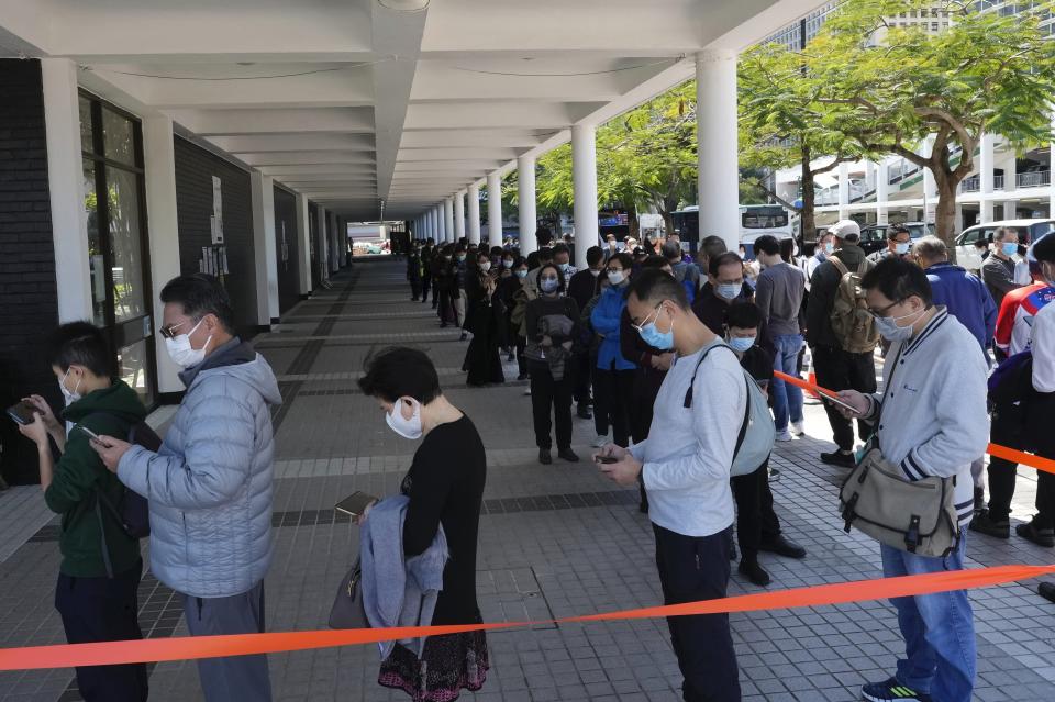 Residents queue up to get tested for the coronavirus at a temporary testing center for COVID-19 in Hong Kong, Monday, Feb. 14, 2022. Hong Kong residents expressed growing frustration last week after new, tighter coronavirus restrictions went into effect, imposed by city leaders in line with Beijing's zero-COVID policy. (AP Photo/Vincent Yu)