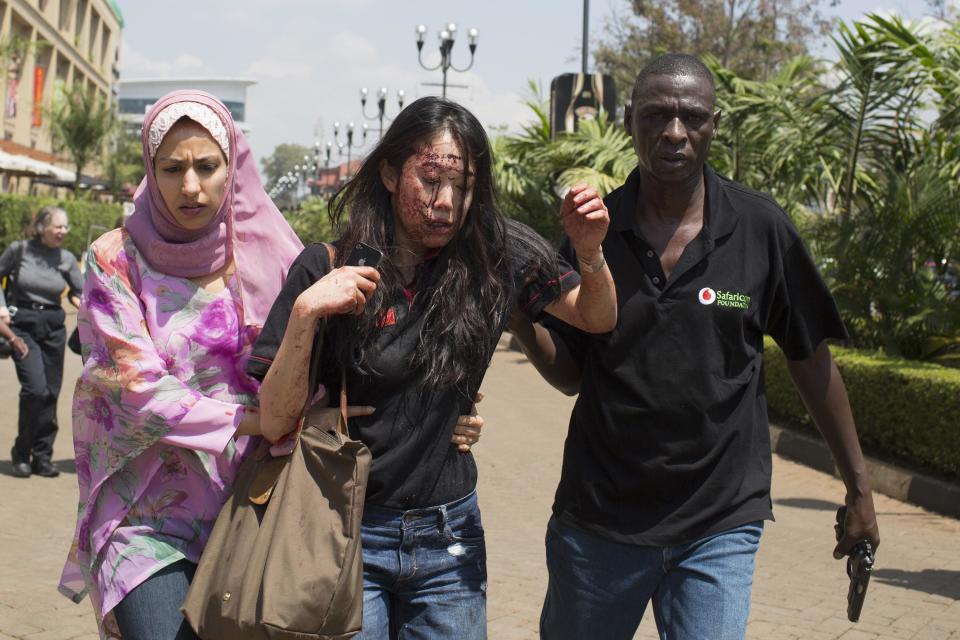 An injured woman is helped out of the Westgate Shopping Centre where gunmen went on a shooting spree, in Nairobi