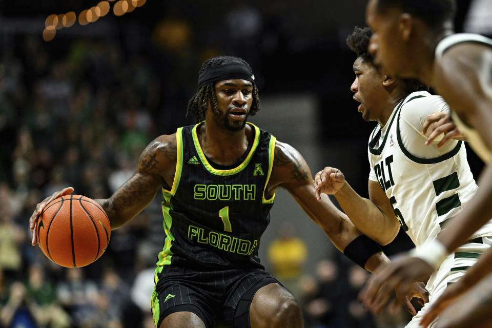 South Florida guard Selton Miguel (1) looks to drive past Charlotte guard Isaiah Folkes (5) during the first half of an NCAA college basketball game on Saturday, March 2, 2024, in Charlotte, N.C. (AP Photo/Matt Kelley)