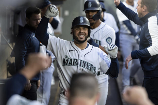 Seattle Mariners' Eugenio Suarez, right, is congratulated by Sam