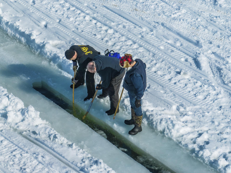 This photo provided by Aroostook UAS shows volunteers creating a giant ice carousel on a frozen lake work on a path curt through the ice on Wednesday, March 29, on Long Lake in Madawaska, Maine. (Aroostook UAS via AP)