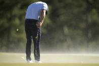 Bryson DeChambeau ducks the wind on the 18th hole during second round at the Masters golf tournament at Augusta National Golf Club Friday, April 12, 2024, in Augusta, Ga. (AP Photo/Ashley Landis)