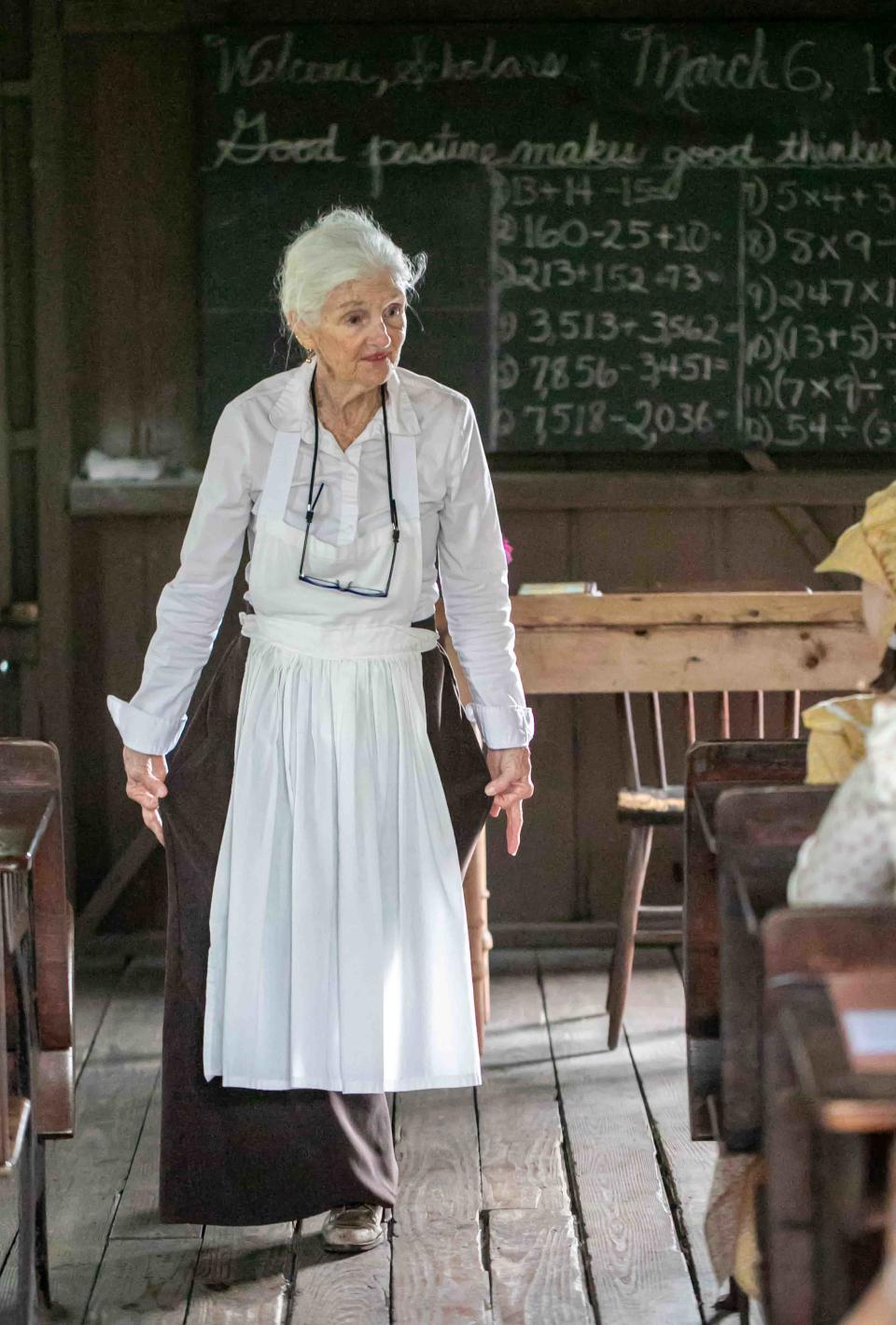 Louise "Jody" Barnett, who plays the role of Ms. Hattie Gale, the schoolmarm at the Little Red Schoolhouse in Palm Beach, teaches fourth grade girls from Rosarian Academy how to curtsy on Wednesday, March 6, 2024.