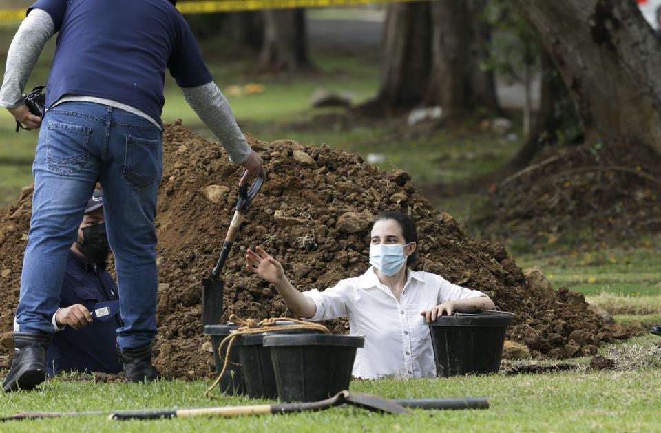 Forensic workers exhume what are believed to be the remains of Lt. Braulio Bethancourt, a victim of the 1989 U.S. invasion, at the Jardin de Paz cemetery in Panama City, Thursday, April 15, 2021. The prosecutor’s office has begun an exhumation of human remains at the Panamanian cemetery in a renewed attempt to confirm the identities of the victims of the U.S. invasion. (AP Photo/Arnulfo Franco)