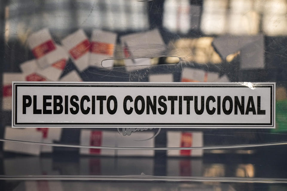 Una caja contiene boletas simuladas colocadas allí para una demostración de votación ante la prensa dentro de un centro cultural en la antigua estación de tren de Mapocho que será un colegio electoral para el próximo plebiscito constitucional en Santiago, Chile, el viernes 15 de diciembre de 2023. (AP Foto/Esteban Félix)