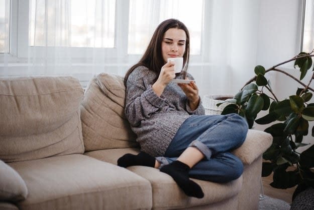 Woman sitting on the couch with coffee