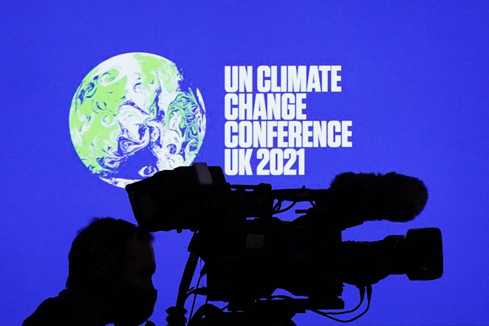 A camera operator records events in a conference room at COP26.