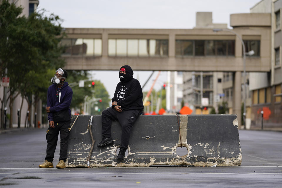 Two men gather outside of Jefferson Square Park following protests over a lack of charges against Louisville police in Breonna Taylor's death, Thursday, Sept. 24, 2020, in Louisville, Ky. (AP Photo/Darron Cummings)