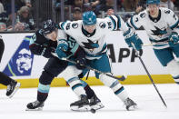 San Jose Sharks center Jack Studnicka (16) battles for the puck with Seattle Kraken right wing Eeli Tolvanen (20) during the second period of an NHL hockey game, Thursday, April 11, 2024, in Seattle. (AP Photo/John Froschauer)
