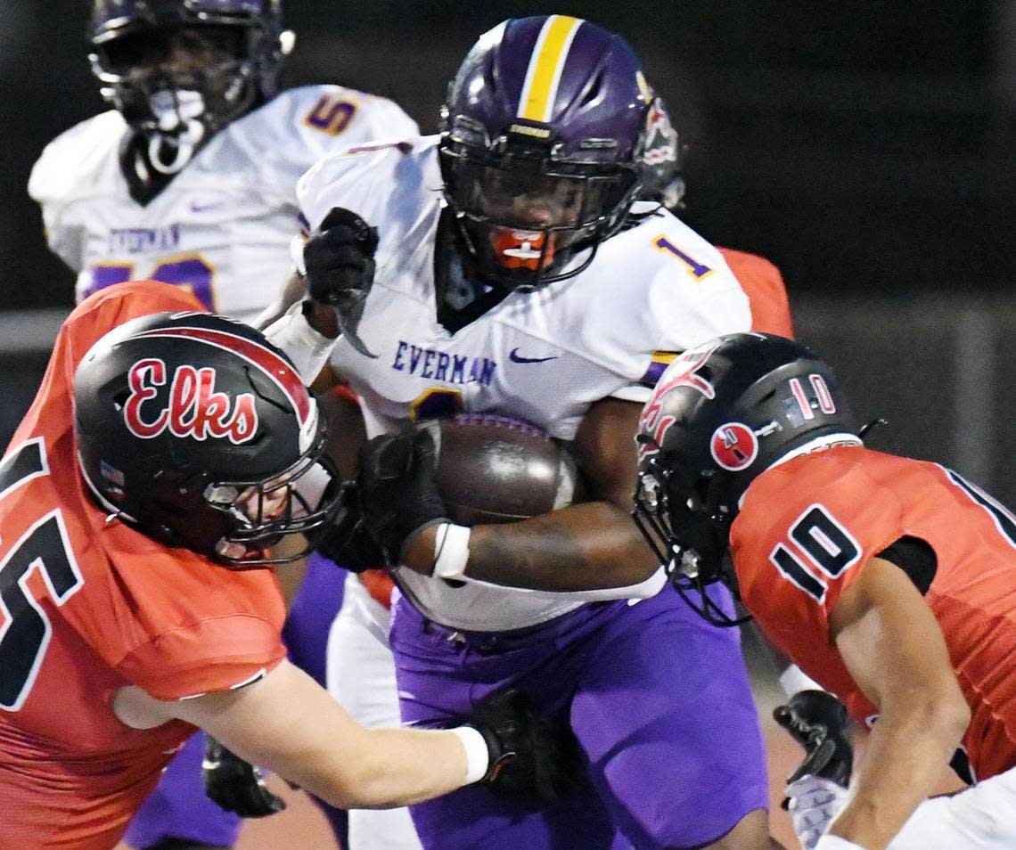 Everman’s Errick Mills, center runs through Burleson’s DJ Greer, left and David Amezcua for close to a first down in the first quarter of Thursday’s October 13, 2022 District 5-5A Division 2 football game at Burleson ISD Stadium in Burleson, Texas. Special/Bob Haynes