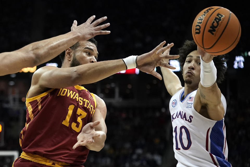 Iowa State guard Jaren Holmes (13) passes under pressure from Kansas forward Jalen Wilson (10) during the first half of an NCAA college basketball game in the semifinal round of the Big 12 Conference tournament Friday, March 10, 2023, in Kansas City, Mo. (AP Photo/Charlie Riedel)