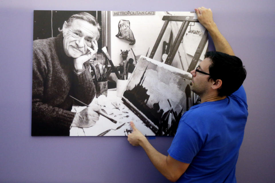 In this Tuesday, July 16, 2013 photo, exhibition technician Ryan Will hangs an image for The Snowy Day and The Art Of Ezra Jack Keats exhibition at the National Museum of American Jewish History, in Philadelphia. The exhibition opened July 19. (AP Photo/Matt Rourke)