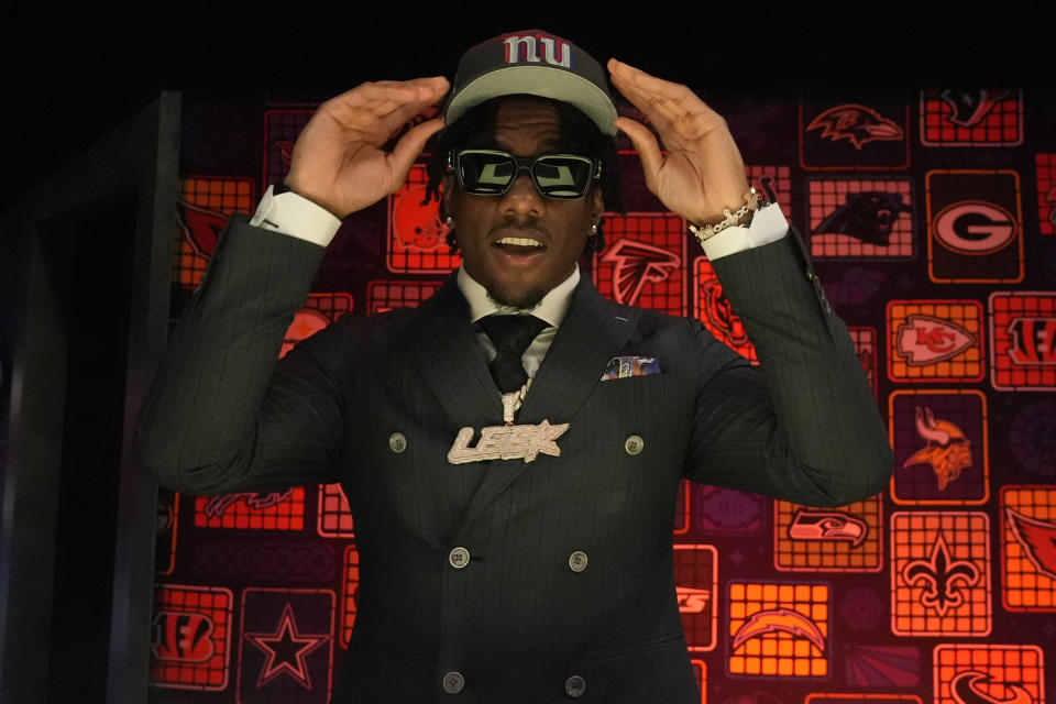 LSU wide receiver Malik Nabers puts on a hat after being chosen by the New York Giants with the sixth overall pick during the first round of the NFL football draft, Thursday, April 25, 2024, in Detroit. (AP Photo/Jeff Roberson)