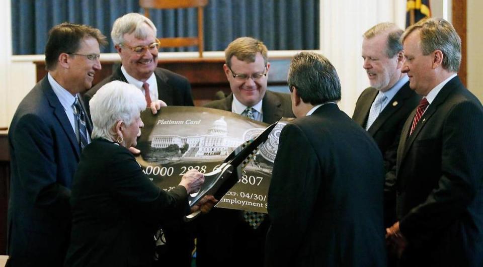In this 2015 file photo, from left, then-Gov. Pat McCrory, State Rep. Julia Howard, Commerce Secretary John Skvarla III, House Speaker Tim Moore, Sen. Bob Rucho, Senate President Pro Tempore Phil Berger and assistant commerce secretary Dale Folwell participate in a ceremonial cutting up of a federal government credit card in the old NC House chamber in the State Capitol. The state announced the complete repayment of its debt to the federal government for unemployment insurance.