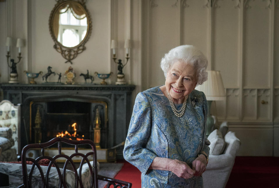 FILE - Britain's Queen Elizabeth II smiles while receiving the President of Switzerland Ignazio Cassis and his wife Paola Cassis during an audience at Windsor Castle in Windsor, England, Thursday, April 28, 2022. Britain is getting ready for a party featuring mounted troops, solemn prayers — and a pack of dancing mechanical corgis. The nation will celebrate Queen Elizabeth II’s 70 years on the throne this week with four days of pomp and pageantry in central London. (Dominic Lipinski/Pool Photo via AP, File)