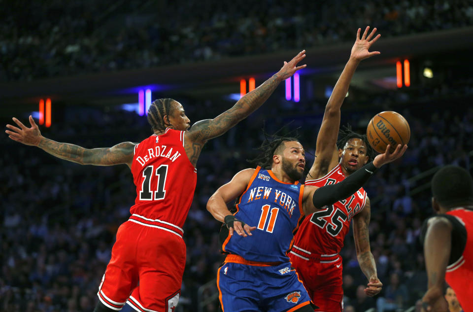 New York Knicks guard Jalen Brunson (11) drives between Chicago Bulls guards DeMar DeRozan (11) and Dalen Terry (25) during the first half of an NBA basketball game Sunday, April 14, 2024, in New York. (AP Photo/John Munson)