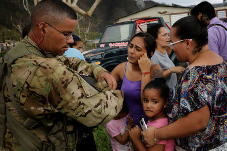 Sergeant First Class Eladio Tirado from the First Armored Division's Combat Aviation Brigade, who is from Puerto Rico, speaks with residents as he helps during recovery efforts following Hurricane Maria, in San Lorenzo, Puerto Rico, October 7, 2017.