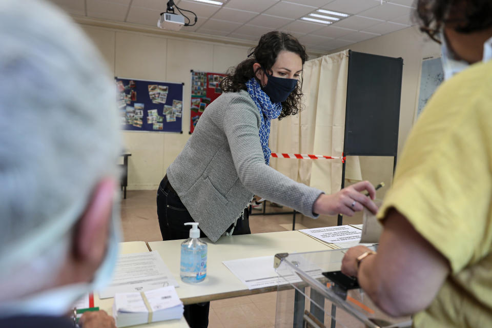 A woman casts a vote at a voting center during the second round of the municipal elections, in Rennes, western France, Sunday, June 28, 2020. France is holding the second round of municipal elections in 5,000 towns and cities Sunday that got postponed due to the country's coronavirus outbreak. (AP Photo/David Vincent)