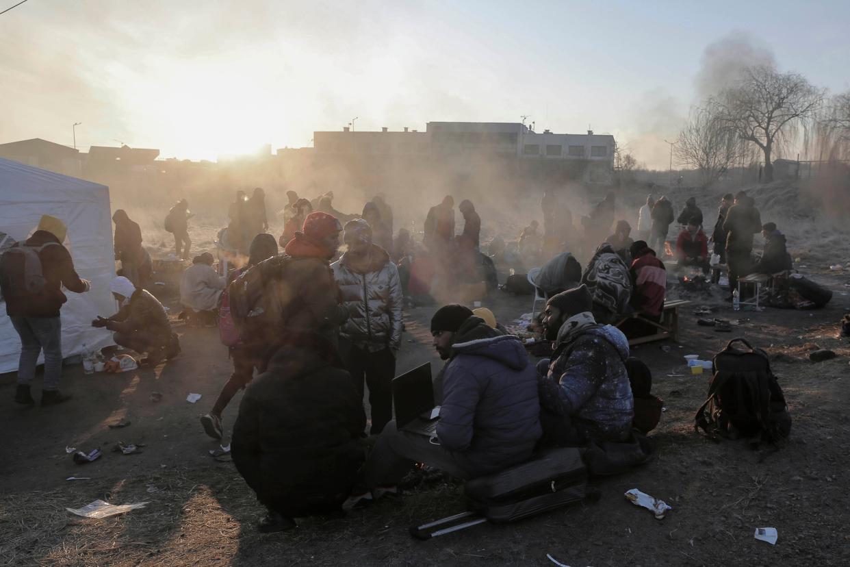 Refugees try to stay warm after fleeing the Russian invasion of Ukraine, at the Medyka border crossing in Poland on Tuesday.