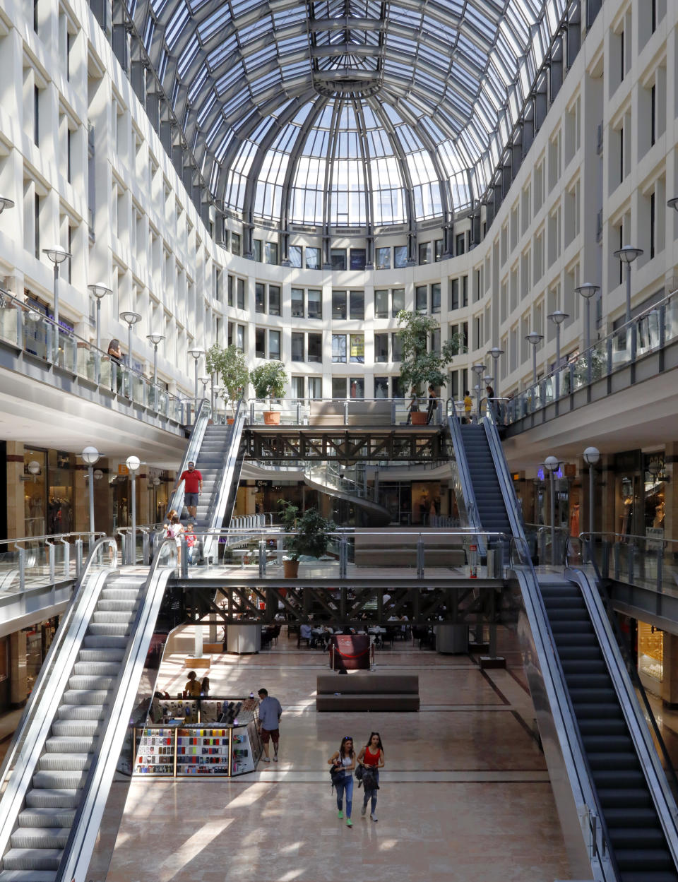 People walk in a shopping mall in Ankara, Turkey, Wednesday, Aug. 15, 2018. Turkey announced increased duties on US products, including cars, tobacco and alcohol, on Wednesday in retaliation to U.S. sanctions and tariffs on Turkey in an on-going feud over the detention of an American pastor.(AP Photo/Burhan Ozbilici)