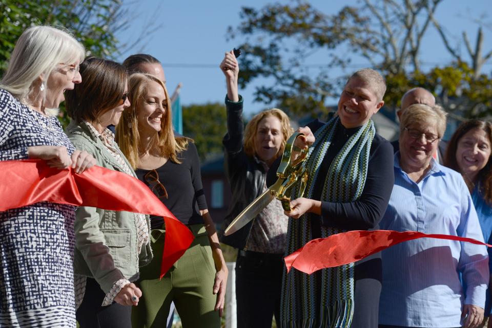 Executive Director of the Cultural Center of Cape Cod, Molly Demeulenaere snips the ribbon at the HyArts Campus on South Street in Hyannis where the Cultural Center is partnering with ArtsBarnstable.