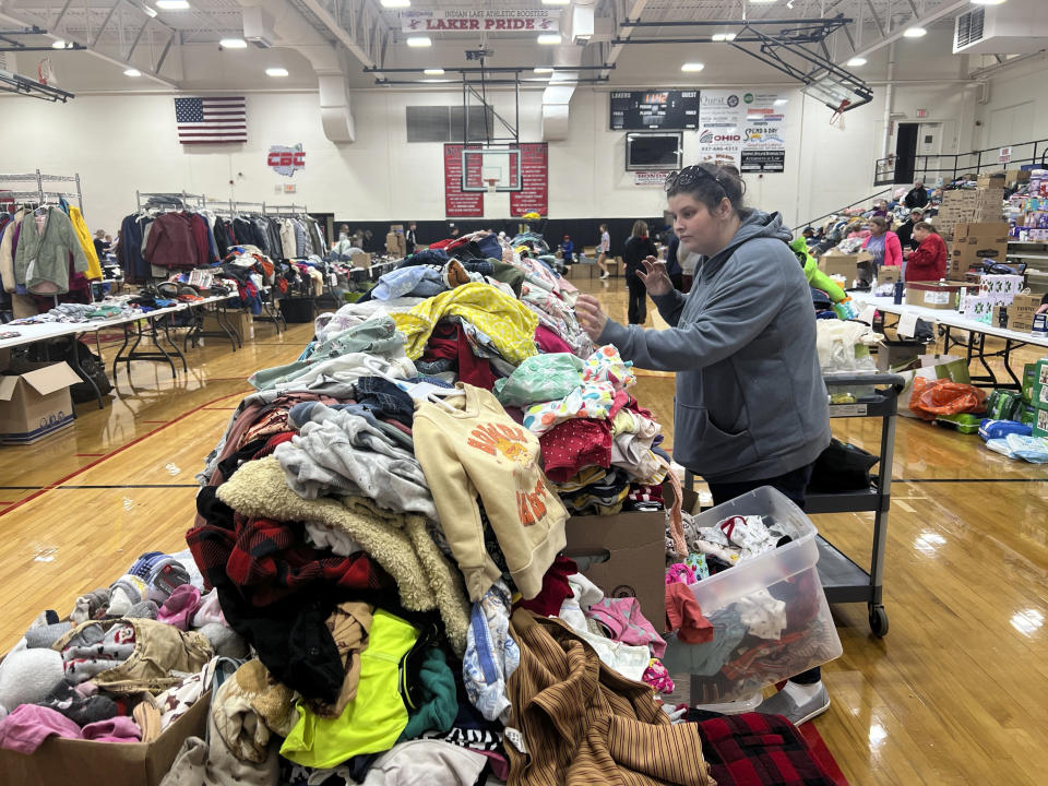 A woman searches through clothing at Indian Lake High School on Saturday, March 16, 2024, in Indian Lake, in Logan County, Ohio. The high school has become a donation center after a tornado swept through the Indian Lake area Thursday. The Indian Lake area in Ohio’s Logan County was one of the hardest hit. (AP Photo/Patrick Orsagos)