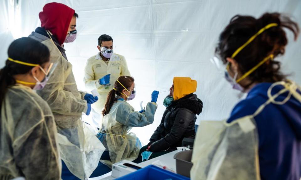 Doctors test hospital staff for coronavirus outside the St Barnabas hospital in New York. White House projections show 100,000 Americans could be killed by the virus.