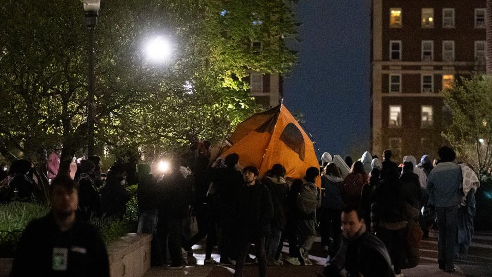 Students move a tent inside Columbia University