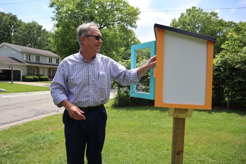 Stow Mayor John Pribonic looks in the Heather Hills Little Free Library.