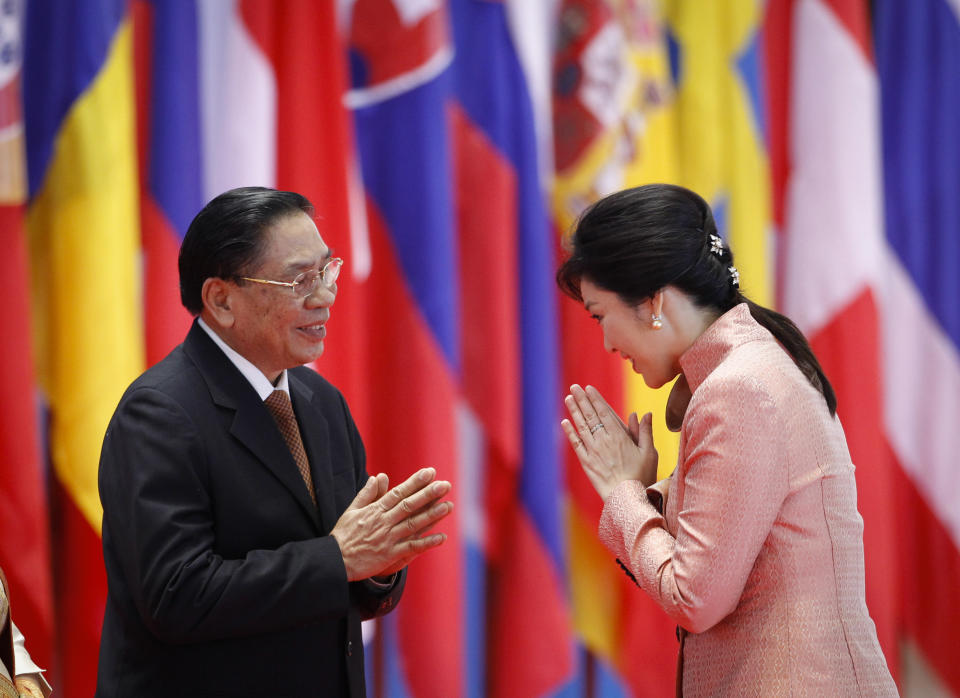 Lao President Choummaly Sayasone, left, greets Thai Prime Minister Yingluck Shinawatra as she arrives for the opening ceremony for the ASEM Summit in Vientiane, Laos, Monday, Nov. 5, 2012. (AP Photo/Vincent Thian)