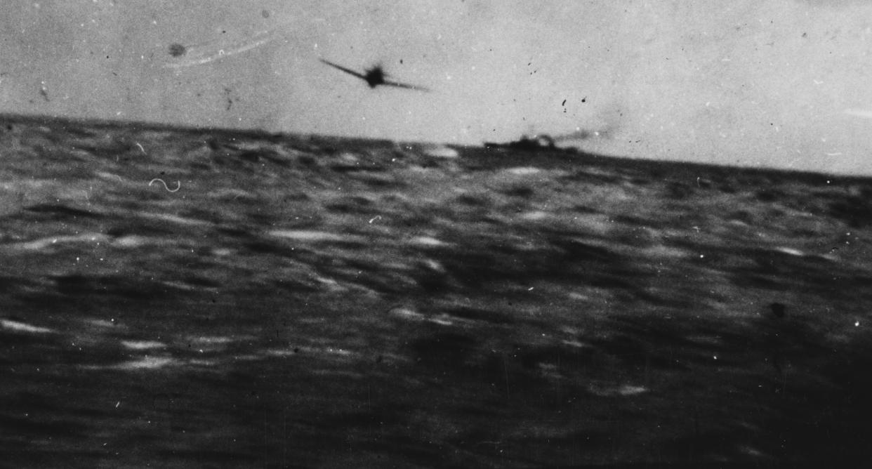 Japanese kamikaze plane about to crash into the USS Kidd off Okinawa April 11, 1945. The plane hit the Kidd's side, killing 38 of her crew. Photographed from the KIDD. Note escorting destroyer in the background.