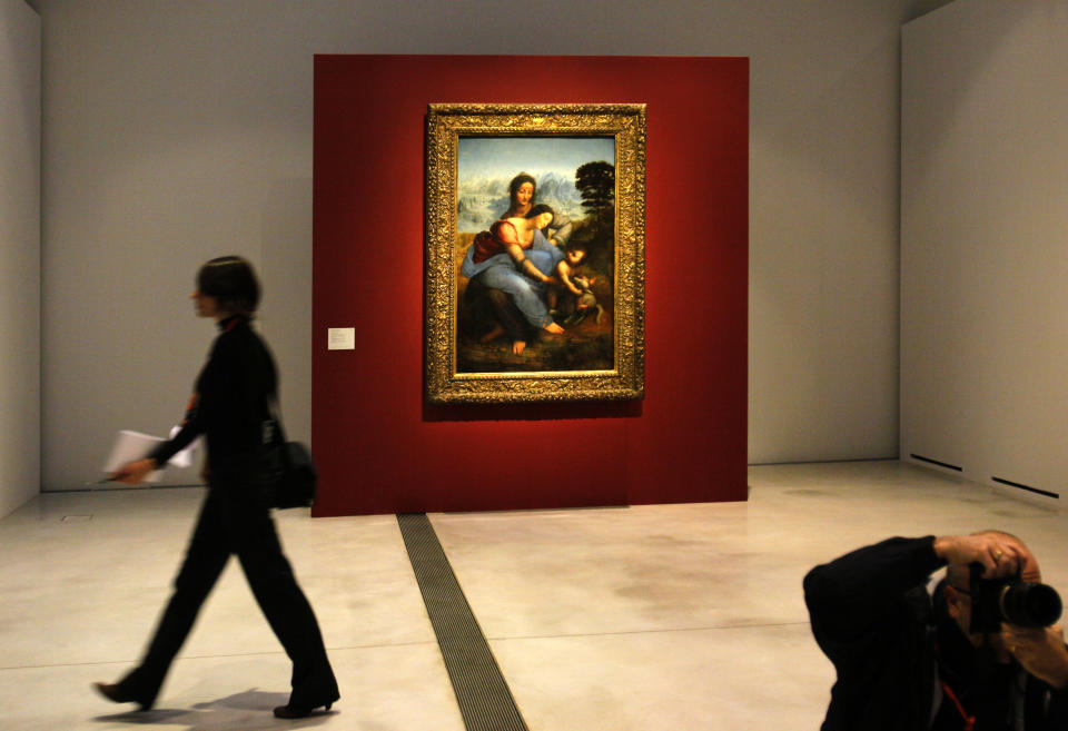 A woman walk past "La Vierge, l'Enfant Jesus et Sainte Anne" by Leonard de Vinci in the Louvre Museum in Lens, northern France, Monday, Dec. 3, 2012. The museum in Lens, to open the 12 Dec, is part of a strategy to spread art beyond the traditional bastions of culture in Paris. (AP Photo/Michel Spingler)