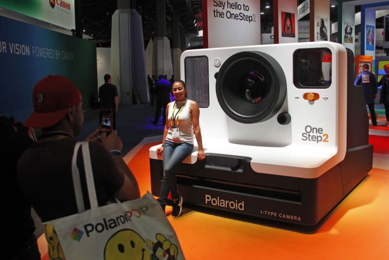 An attendee poses in front of a giant model of a Polaroid instant camera during the 2018 International CES at the Las Vegas Convention Center on January 9. On November26, 1948, the first commercial Polaroid camera was sold. The inventor of the device and founder of Polaroid Corp., Edwin H. Land, obtained some 533 patents before his death in 1991. File Photo by James Atoa/UPI