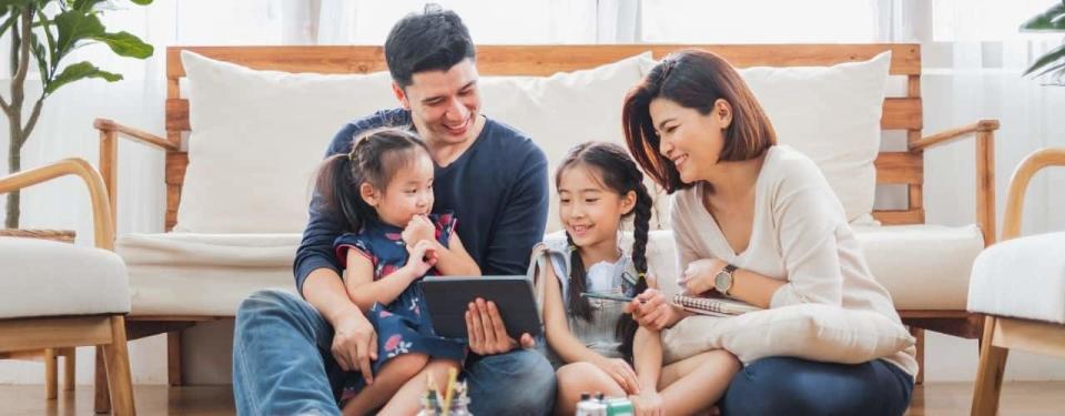 family using tablet, laptop for playing game watching movies, relaxing at home