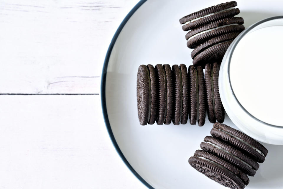 Top view of Oreo cookies in three horizontal stacks arranged around a glass of milk