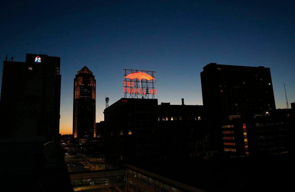 The Travelers Insurance sign glows atop the Des Moines skyline.