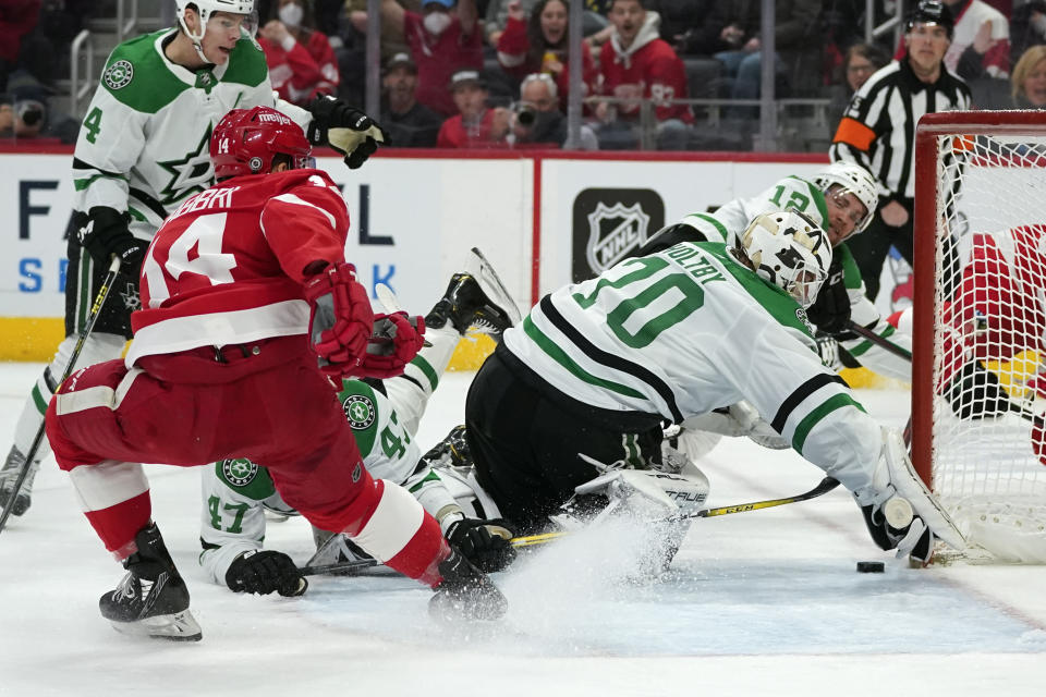 Dallas Stars goaltender Braden Holtby (70) covers the puck as Detroit Red Wings center Robby Fabbri (14) watches for a rebound in the second period of an NHL hockey game Friday, Jan. 21, 2022, in Detroit. (AP Photo/Paul Sancya)