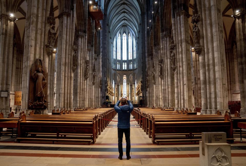 A tourist takes a picture inside the Cologne Cathedral in Cologne, Germany, Wednesday, Nov. 30, 2022. An unprecedented crisis of confidence is shaking the Archdiocese of Cologne. Catholic believers have protested their deeply divisive bishop and are leaving in droves over allegations that he may have covered up clergy sexual abuse reports. (AP Photo/Michael Probst)