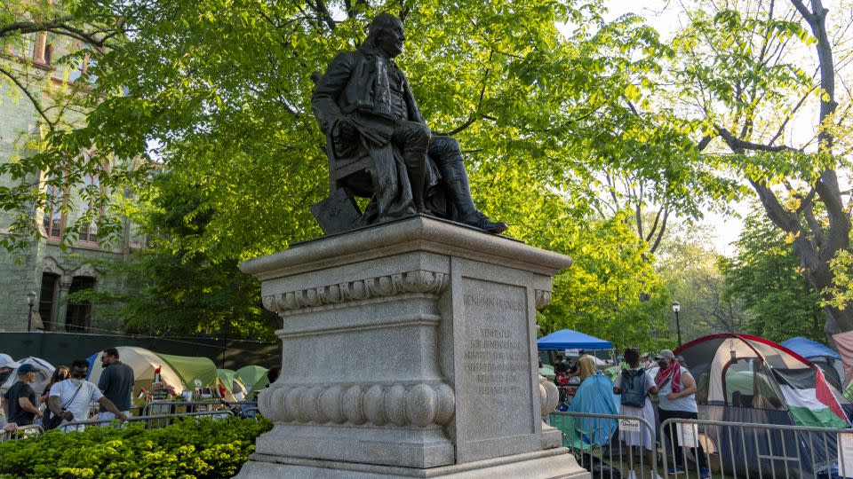 Protesters at the University of Pennsylvania flank a statue of Benjamin Franklin. - Evelio Contreras/CNN