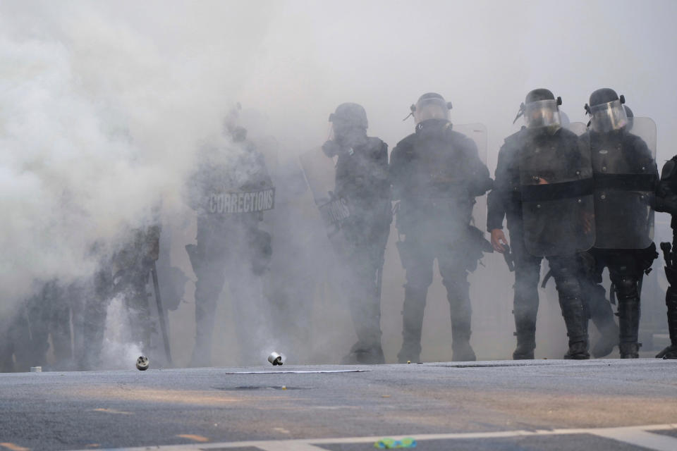 Police stand near tear gas during a demonstration Monday, June 1, 2020, in Atlanta over the death of George Floyd, who died May 25 in Minneapolis. (Ben Gray/Atlanta Journal-Constitution via AP)