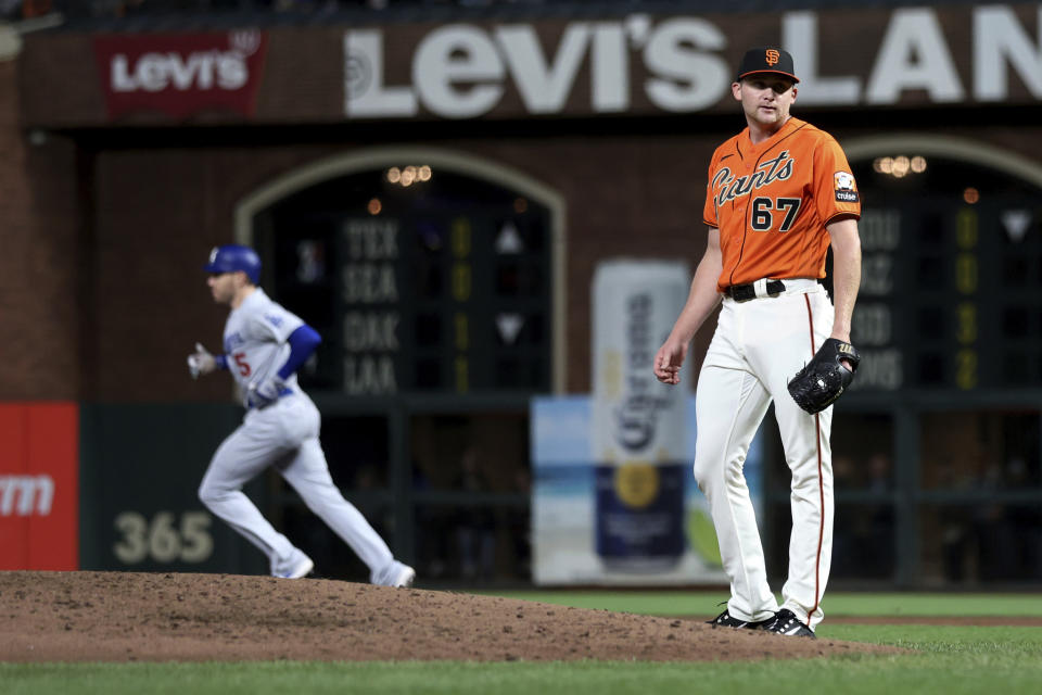 Los Angeles Dodgers' Freddie Freeman, left, runs the bases after hitting a home run off San Francisco Giants' Keaton Winn (67) during the third inning of a baseball game in San Francisco, Friday, Sept. 29, 2023. (AP Photo/Jed Jacobsohn)