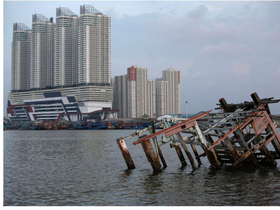 Pollution coronavirus A combination picture shows a man walking on top of the wreckage of a wooden boat, as smog covers the sky, July 26, 2018, (top) and a view of the same location pictured during the coronavirus disease (COVID-19) outbreak, in North Jakarta, Indonesia