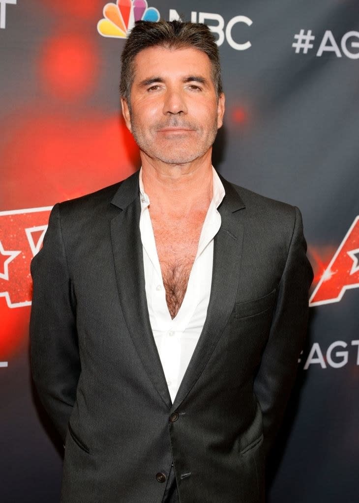 Simon Cowell looking straight at the camera and smiling slightly